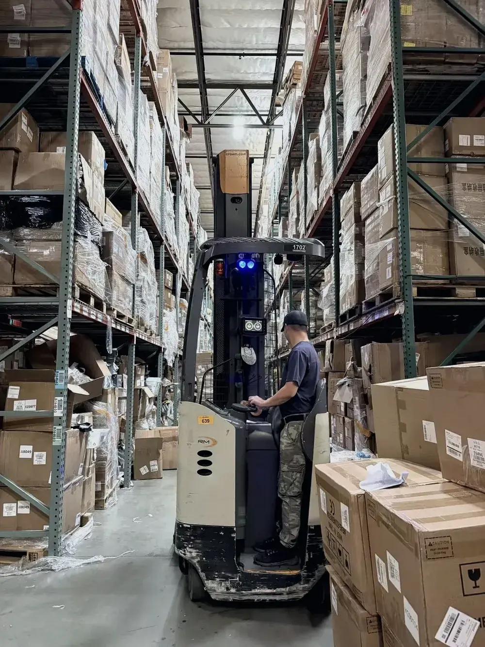 Forklift moving wrapped pallets inside the warehouse